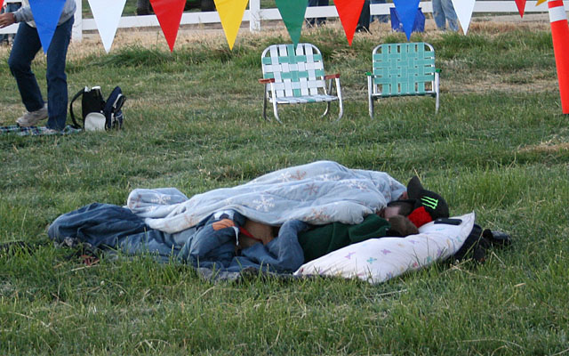 There are people who prefer spending the night at the launch site rathe than getting up at 4:00 am. Under the blanket is a young couple, a child, and a puppy.